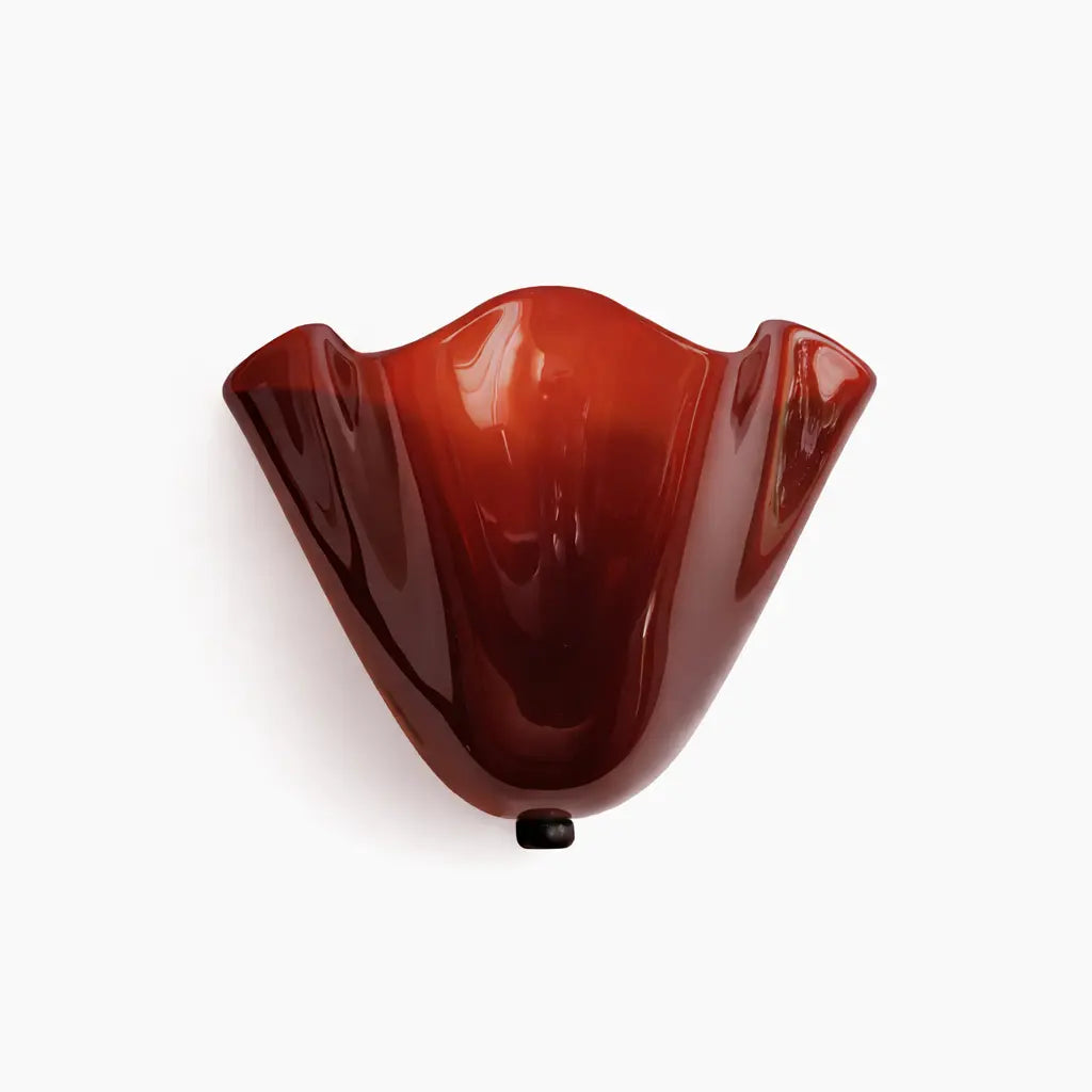 Red tinted glass wall sconce with sculpted scalloped design