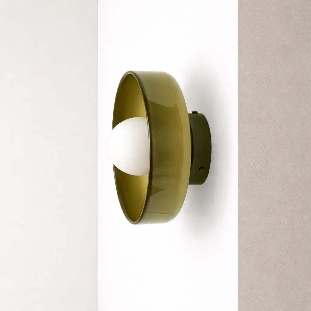Olive green wall light with opal glass globe and black mounting base