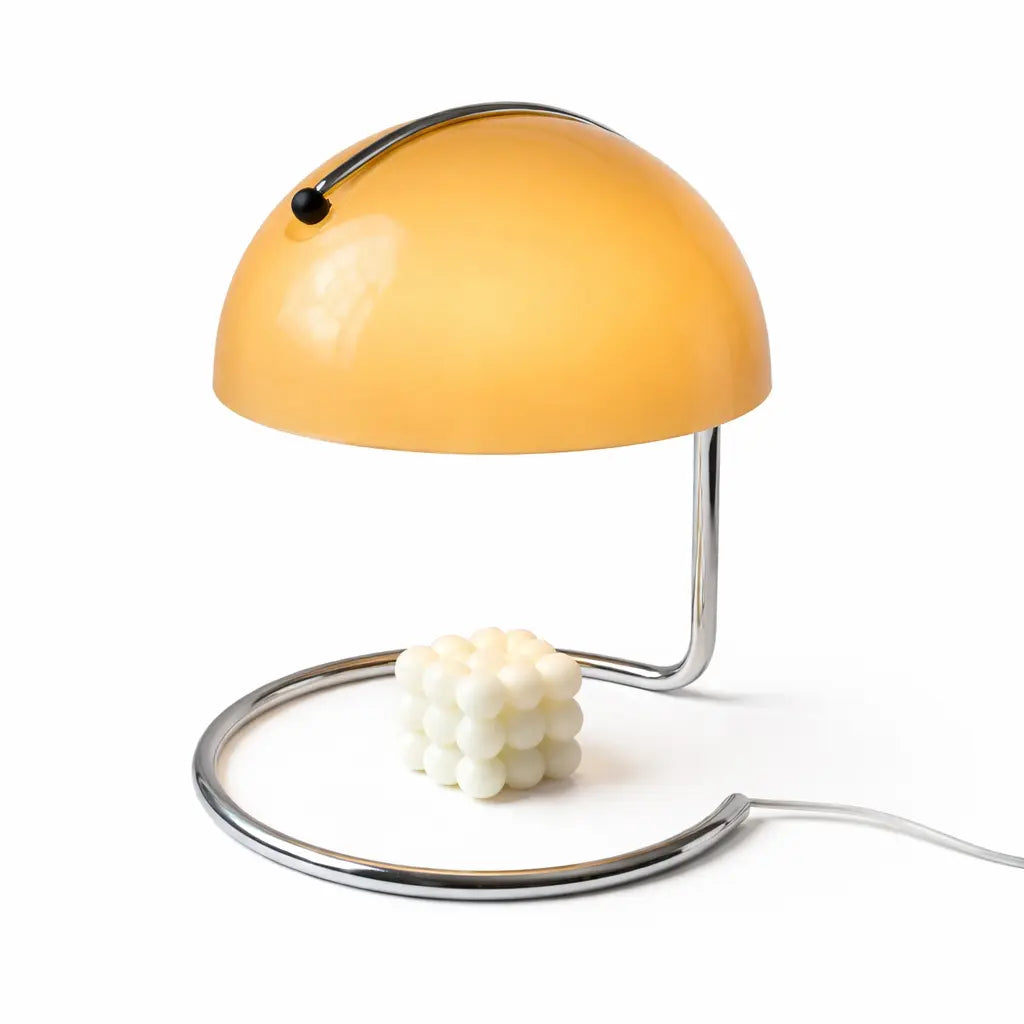 Yellow dome candle warmer lamp with curved chrome stand and bubble candle.