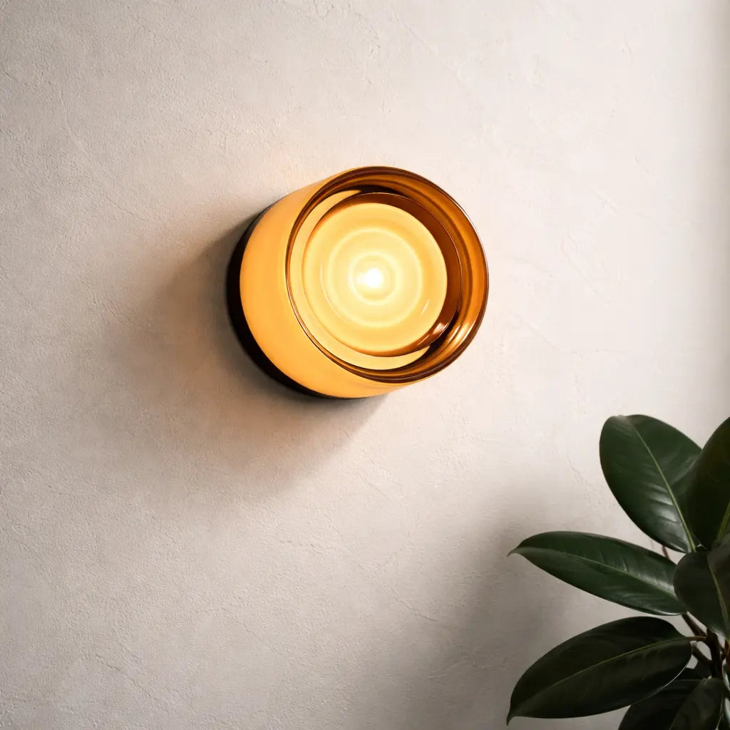 Amber glass round wall sconce lit on textured wall